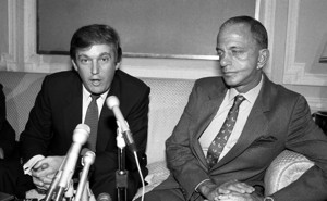 A black and white photo of Donald Trump sitting in front of microphones next to Roy Cohn.