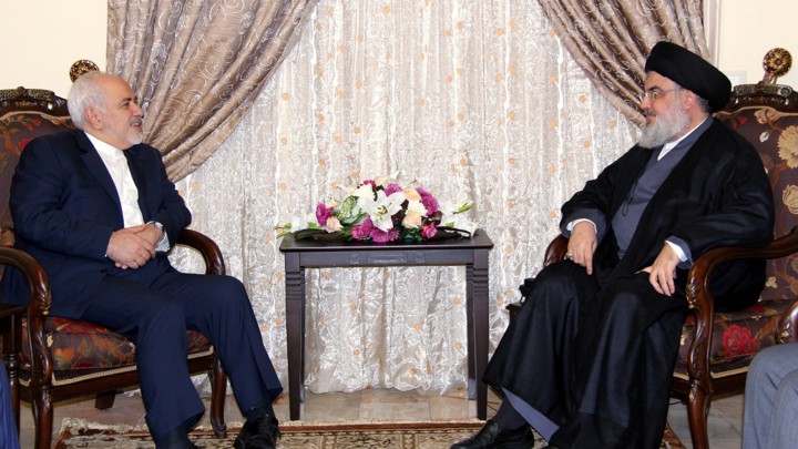 Sayyed Hassan Nasrallah and Javad Zarif sit facing each other.