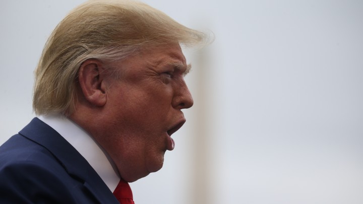 President Trump shouts at reporters on the South Lawn of the White House, with the Washington Monument in the background.