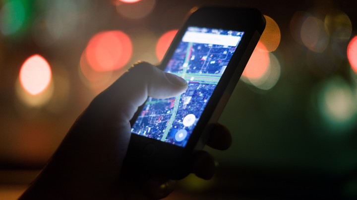 A hand holding a phone with a map open