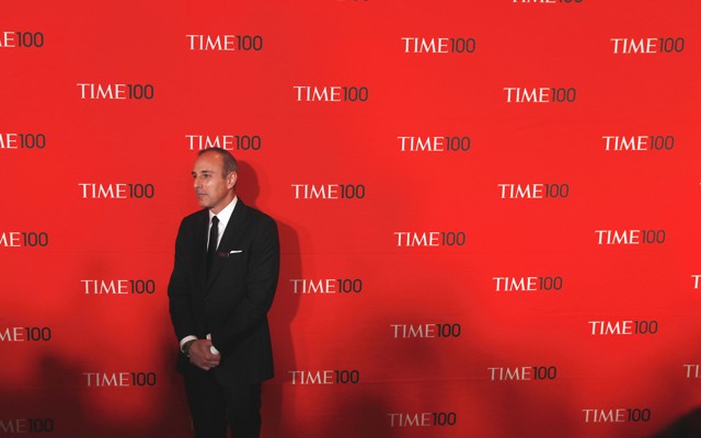 Matt Lauer stands in a suit in front of a red backdrop with the words "Time 100" written repeatedly behind him.