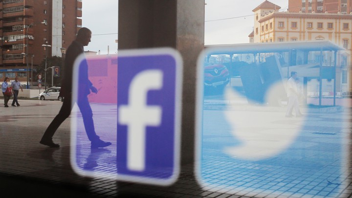 The reflection of the Twitter and Facebook logos in a shop window