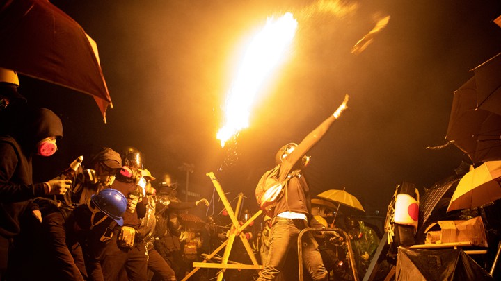 Anti-government protesters throw Molotov cocktails during clashes with police outside Hong Kong Polytechnic University.