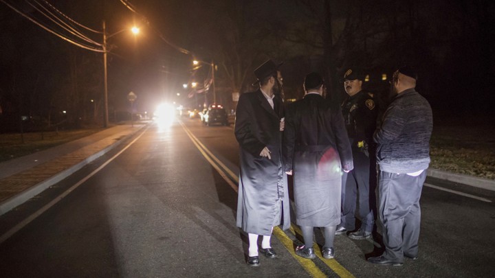 Orthodox Jews near the scene of a late-Saturday stabbing