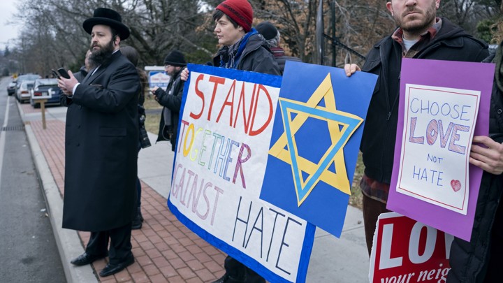 Neighbors gather to show their support of the community near a rabbi's residence in Monsey, New York, following a stabbing Saturday night.