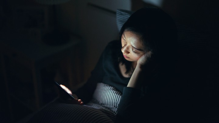 Woman using phone in bed