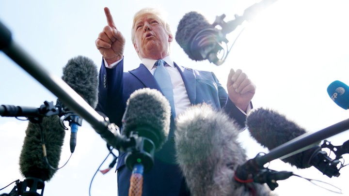 Donald Trump surrounded by microphones