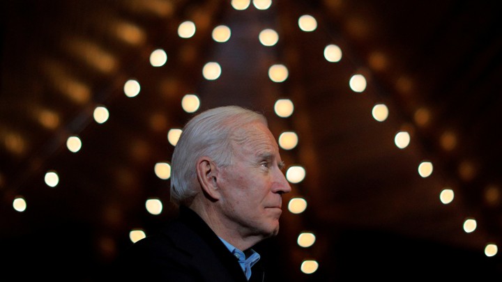 Joe Biden looks up at the ceiling, surrounded by small lights.