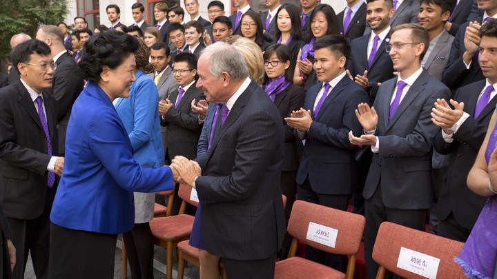 Liu Yandong shakes hands with Stephen Schwarzman as the first class of Schwarzman scholars applaud.