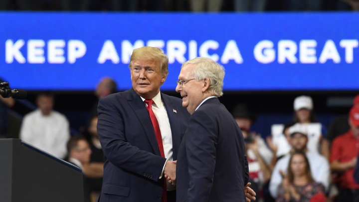 President Donald Trump attends Game 5 of the World Series with several congressional Republicans. He is waving at the crowd.