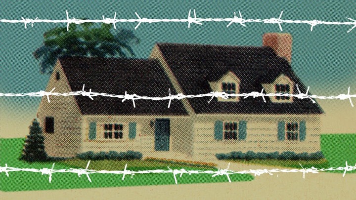 A house behind white barbed wire.