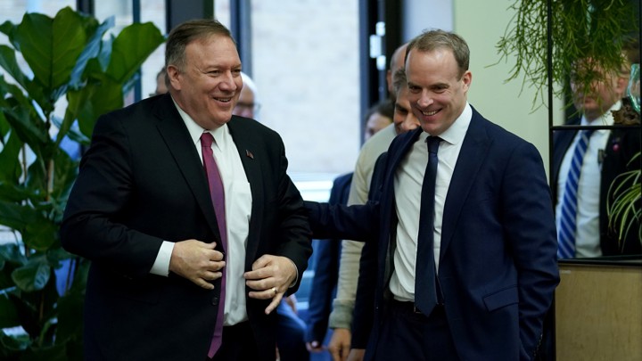 Mike Pompeo and Dominic Raab walk side by side.