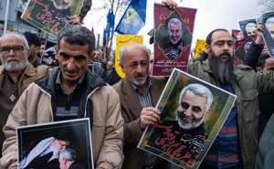 Protesters holding posters of Qassem Suleimani