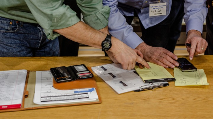 Volunteers do a head count at t​he caucus site at Drake University, in Des Moines, Iowa.