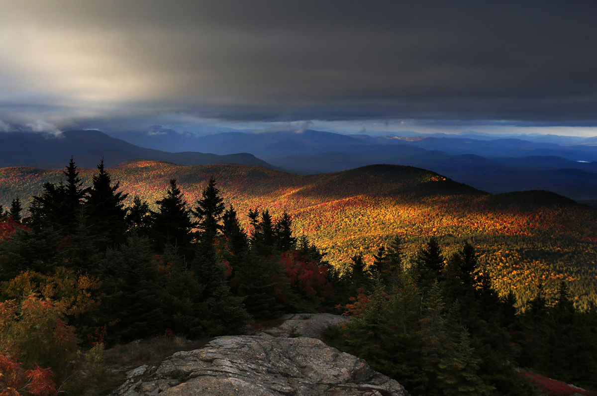 Fall foliage colors a line of mountains in Chatham, New Hampshire, as