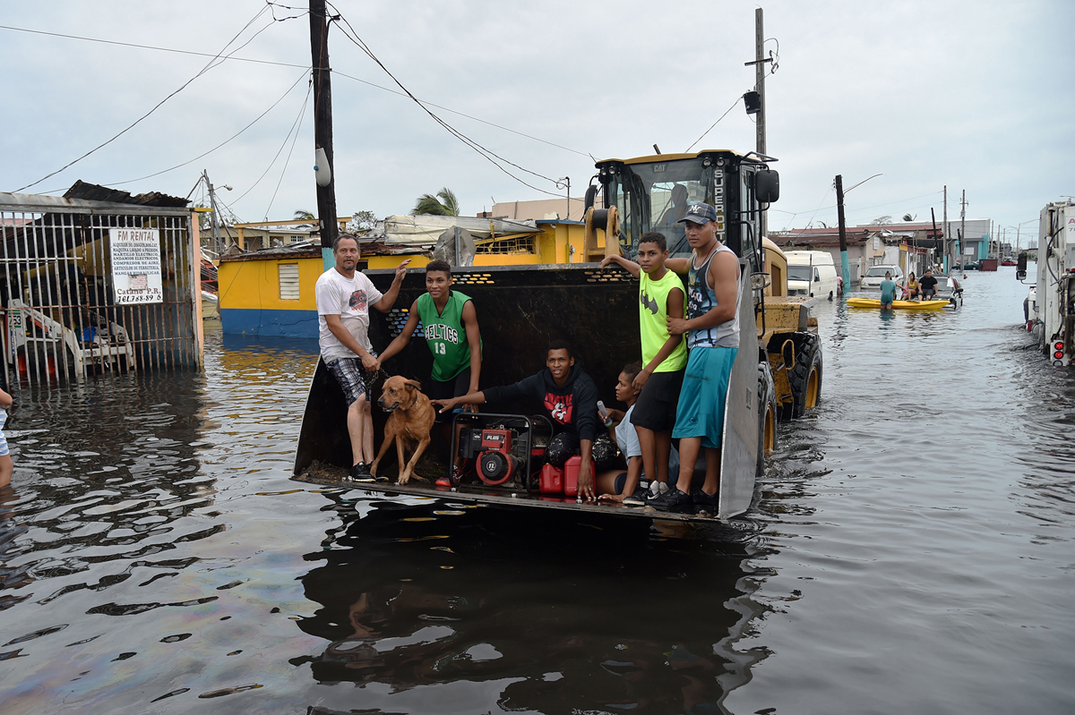 People are transported down a road flooded by Hurricane Maria in Juana Matos, Catano, Puerto Rico, on September 21, 2017. (Atlantic Magazine)