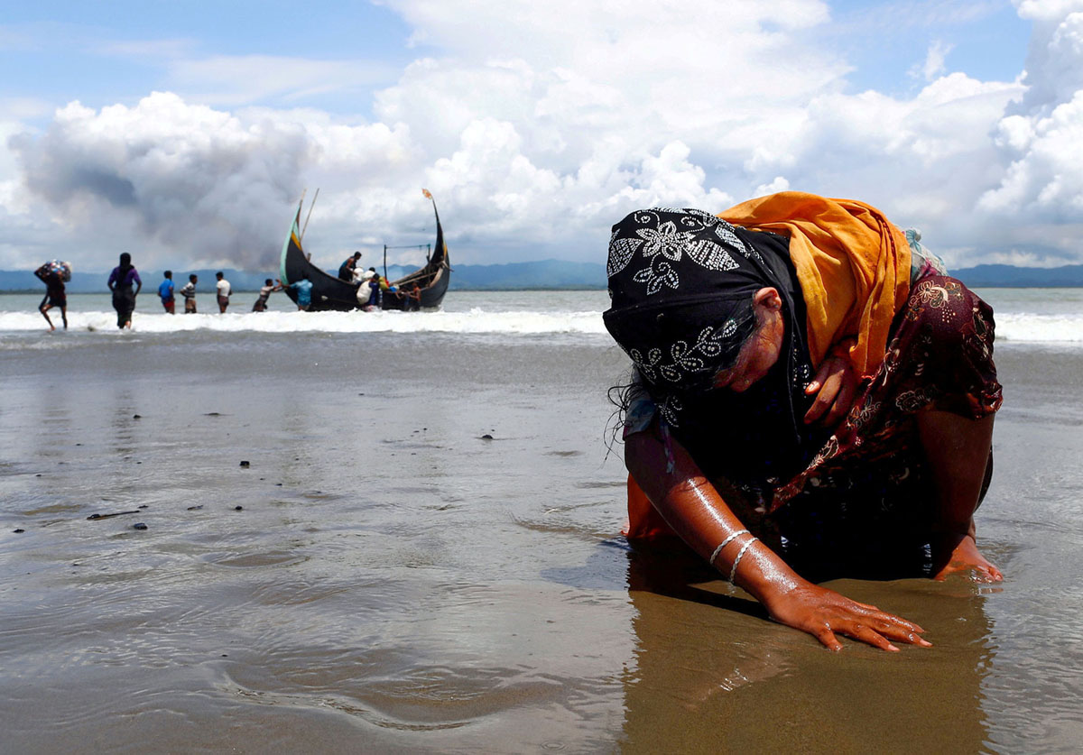 An exhausted Rohingya refugee woman touches the shore. Photo by Daanish Siddiqui.
