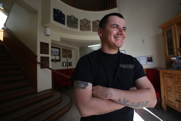 A man stands smiling with his arms crossed