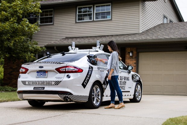 An autonomous Ford Fusion delivering pizza is pictured.