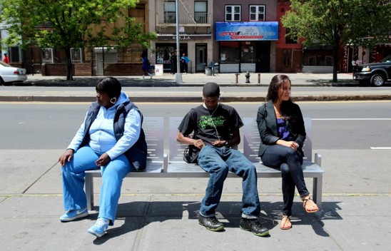 New Yorkers sit on a bench in Harlem