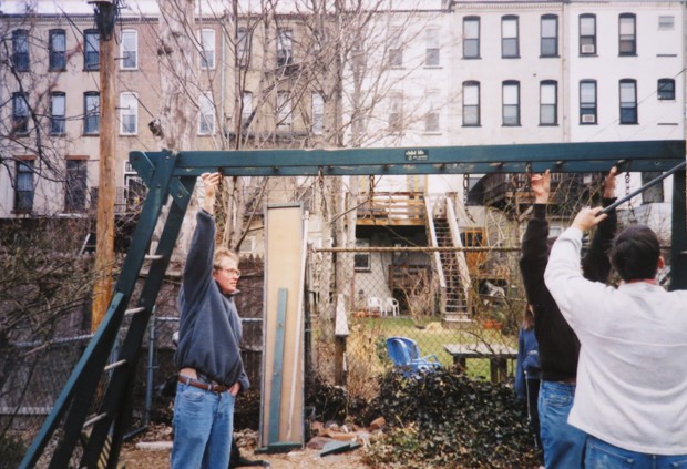 Neighbors are pictured building a swing set in the back yard.