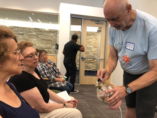 A volunteer and attendees at a Repair Cafe are pictured.