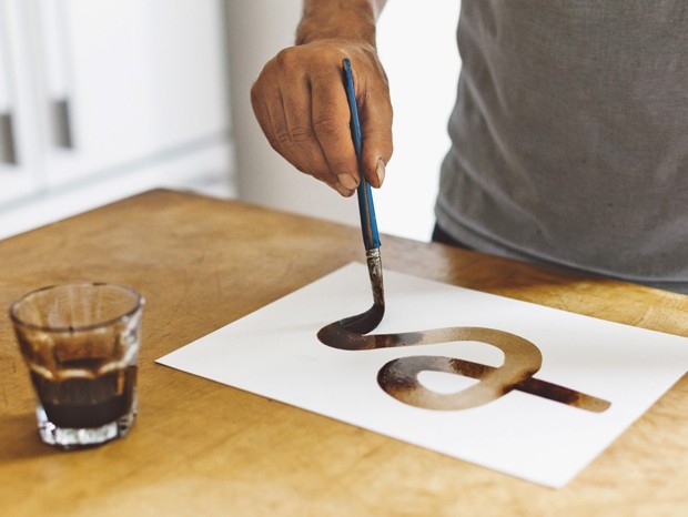 A photo shows ink being painted on a piece of paper.