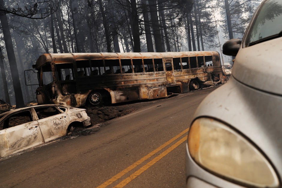 Abandoned, burnt vehicles litter the road leaving Paradise, California.