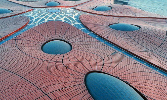 An aerial view of people working on the roof of what's being billed as the world's largest single-terminal airport