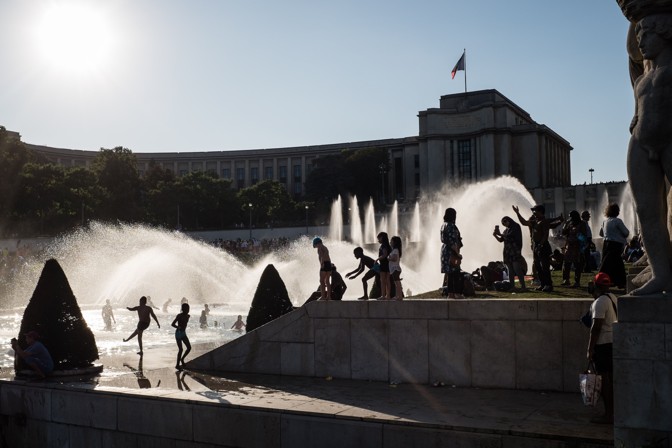 Parisians and tourists jump through Paris's Trocadero Fountains.