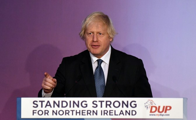 Boris Johnson speaks at the Democratic Unionist Party (DUP) annual party conference in Belfast. The sign on his podium reads 'Standing Strong for Northern Ireland.' 