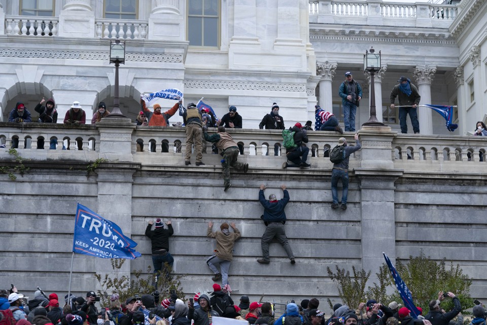 people scaling wall of capitol