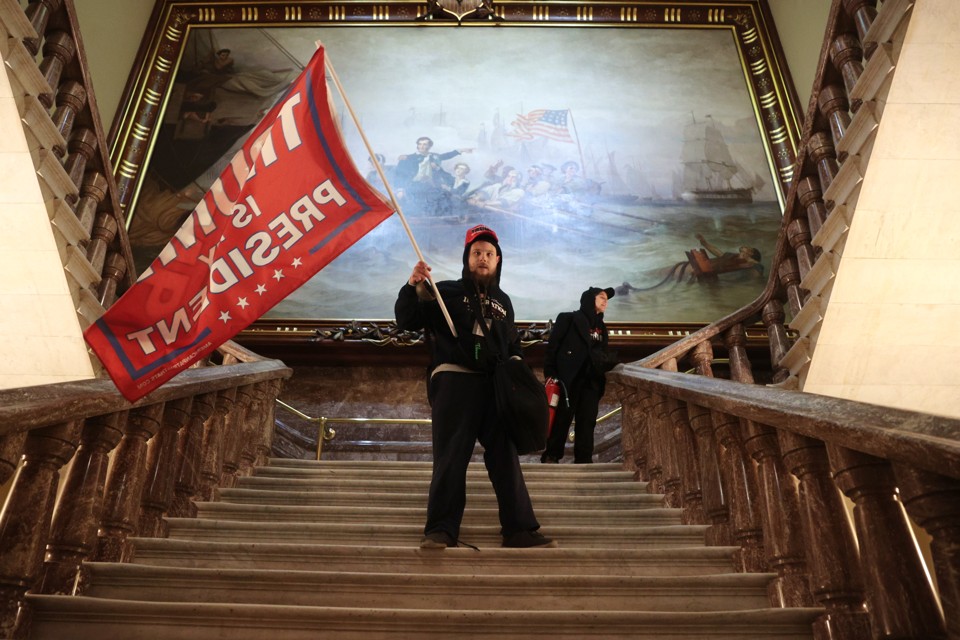 Man holding Trump flag in Capitol building