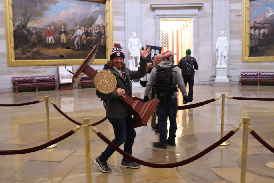 insurrectionist walking off with podium