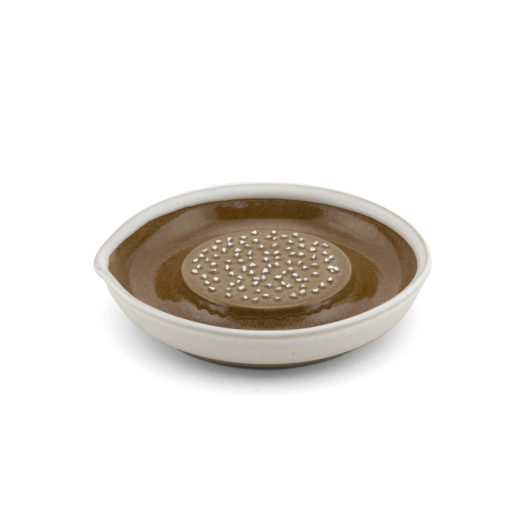 A white and brown ceramic grater. 