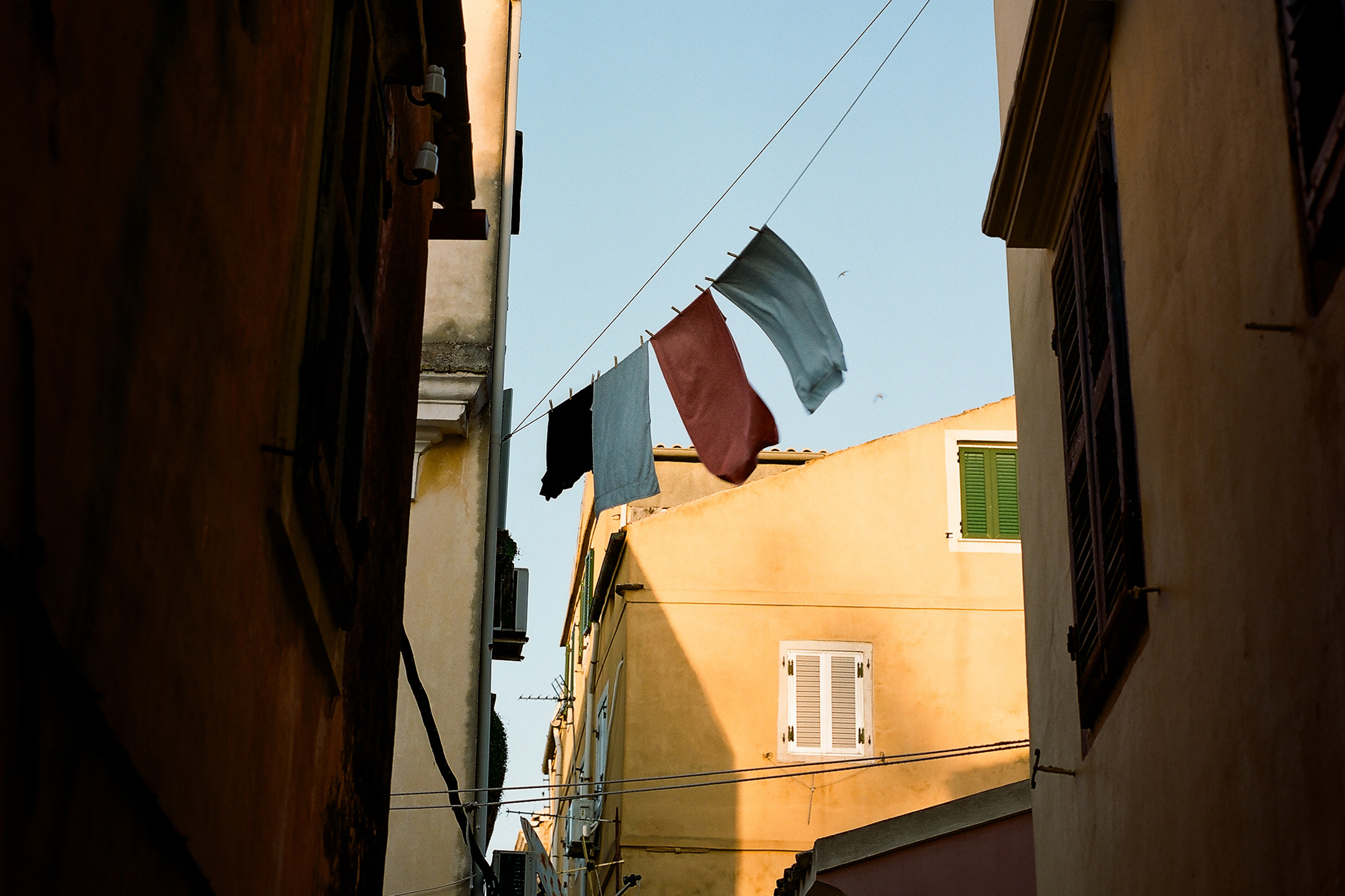 Photo of a narrow street in Corfu’s Old Town, with laundry hanging from above.