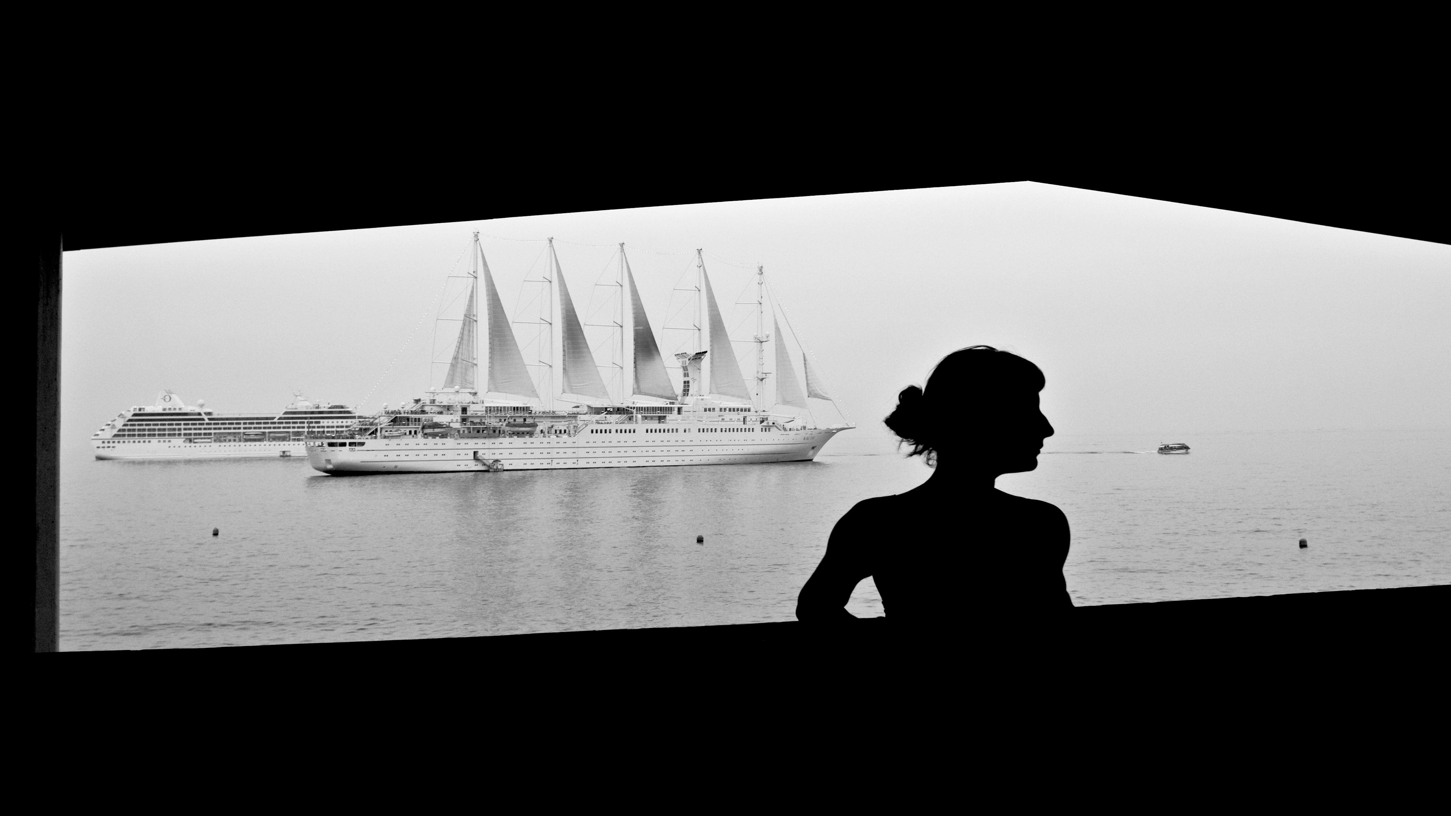 A woman posing in front of a cruise ship