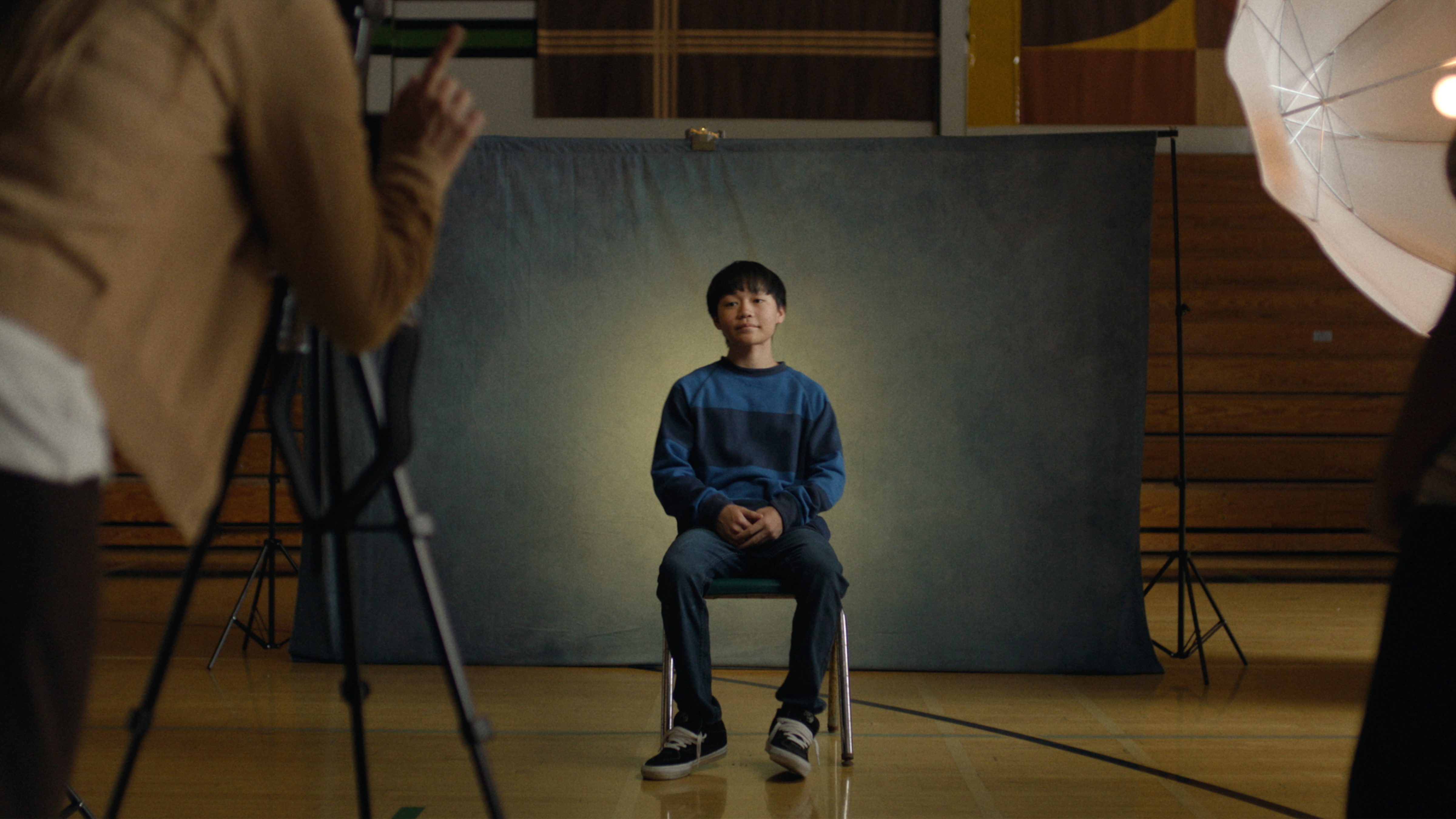 Izaac Wang sitting in front of a photo-shoot backdrop