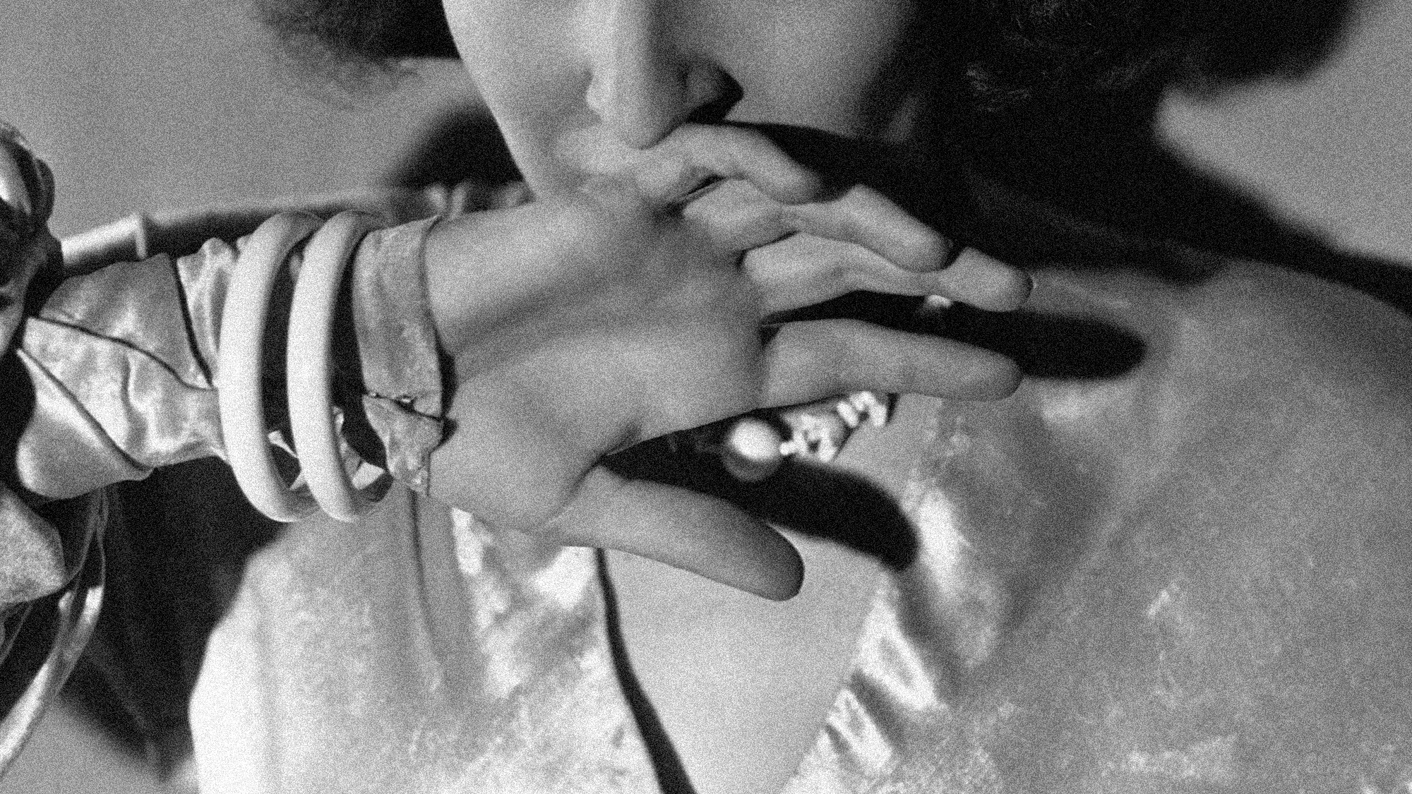 A woman holds her hand to her mouth.