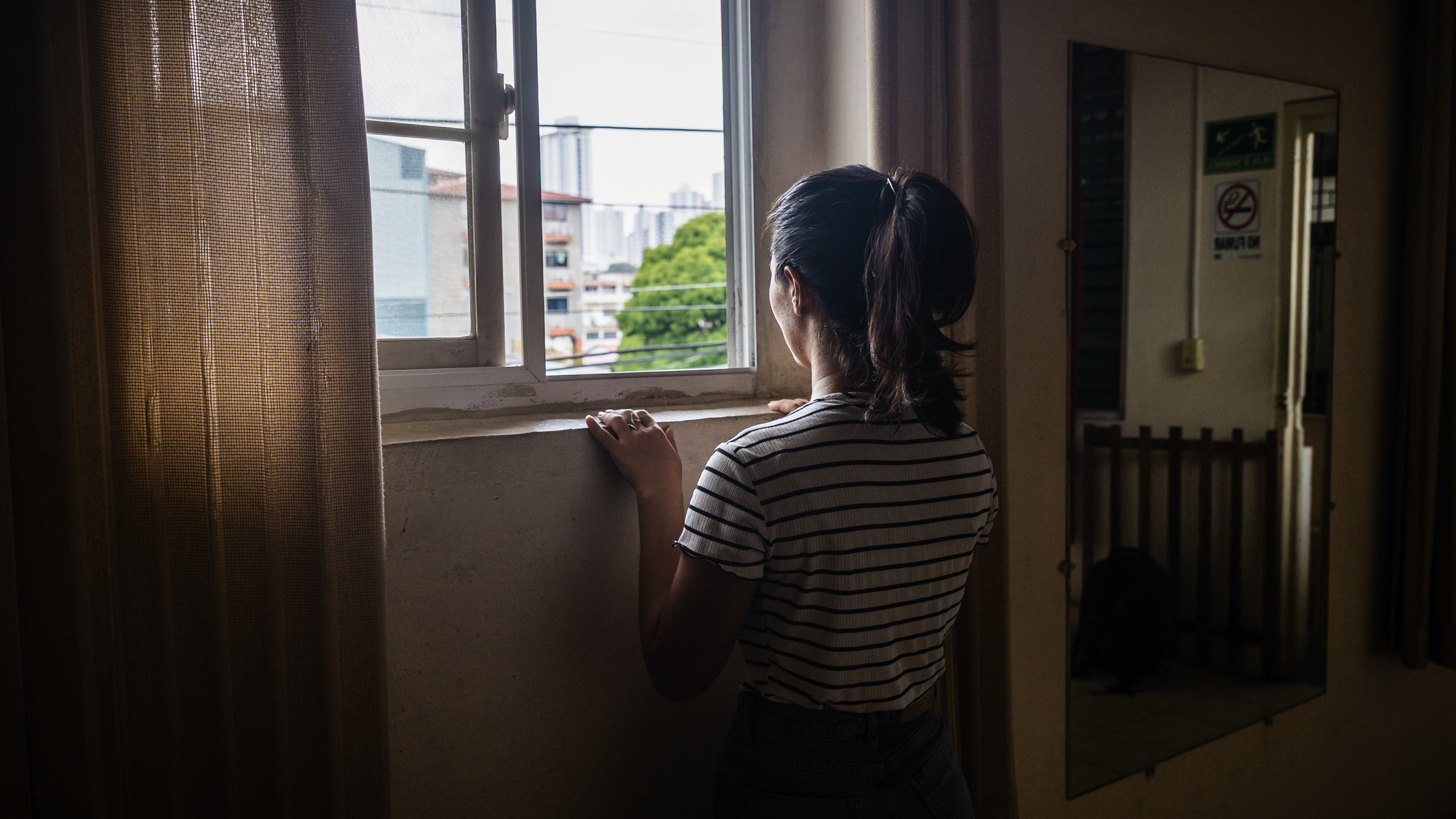 A woman looks out a window