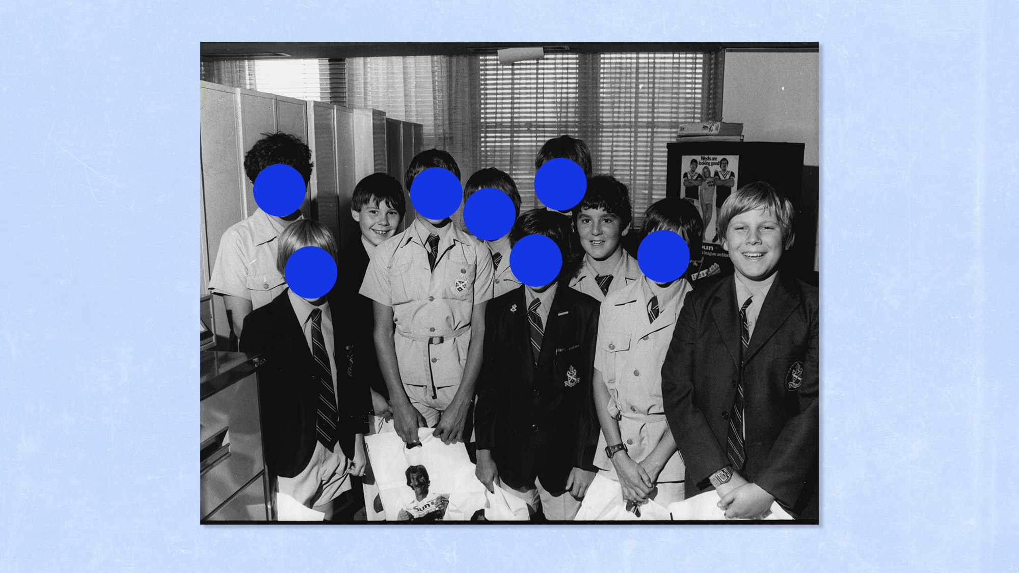 A black-and-white photo of 10 boys smiling for the camera, several of their faces obscured by blue dots