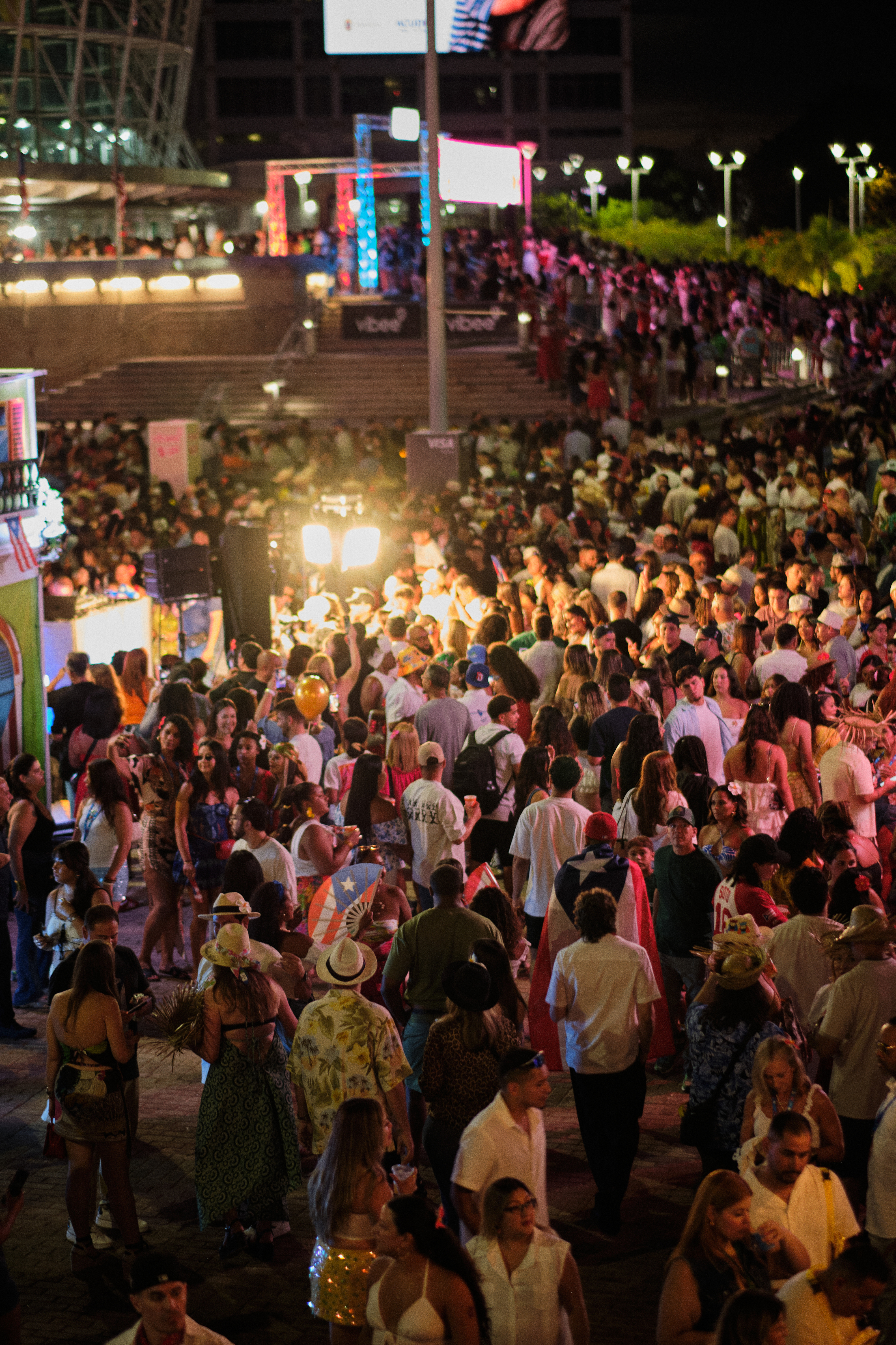 A color photograph of a crowd outside a concert venue at night