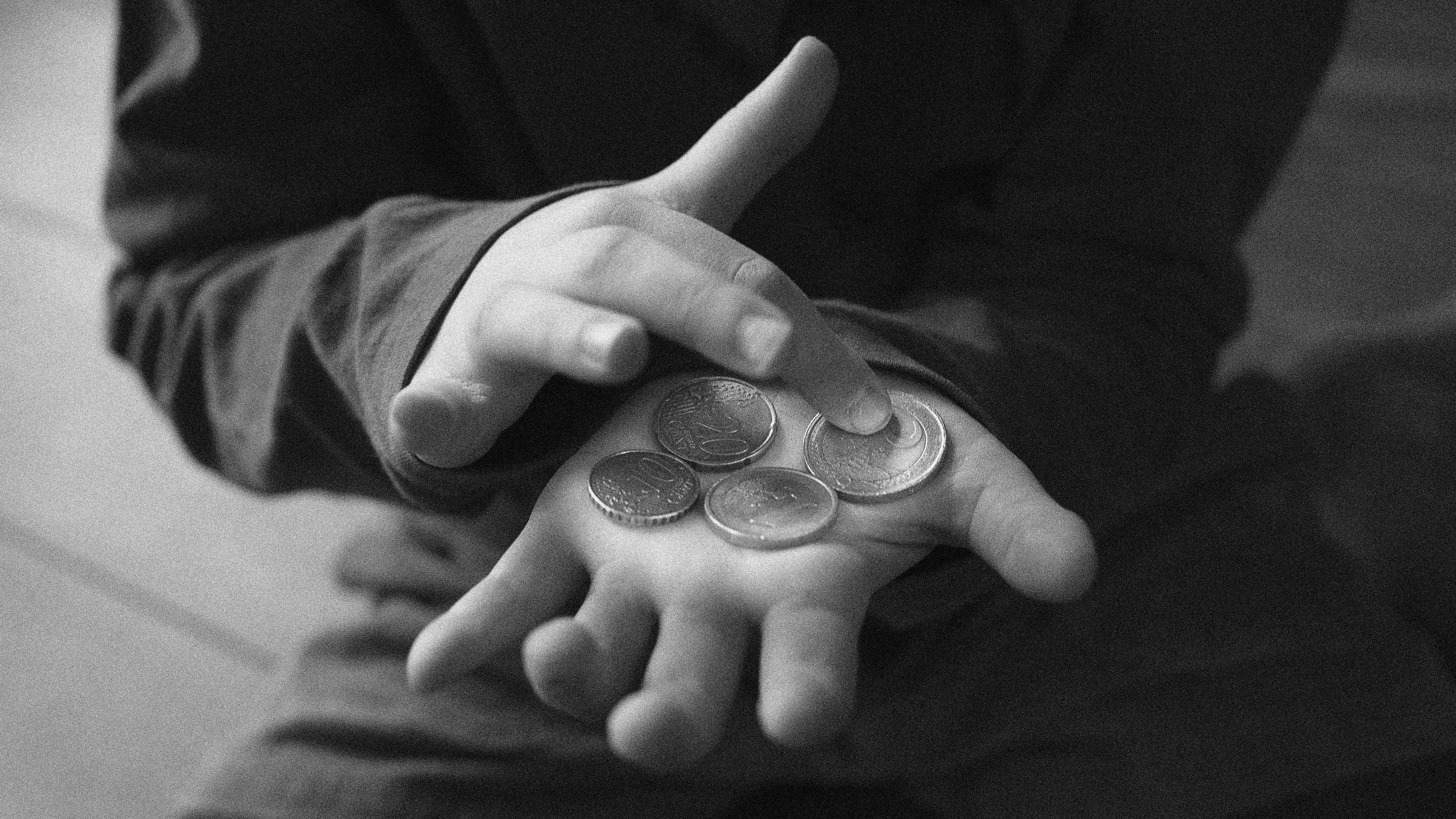 Close-up photo of a child holding coins in their hands