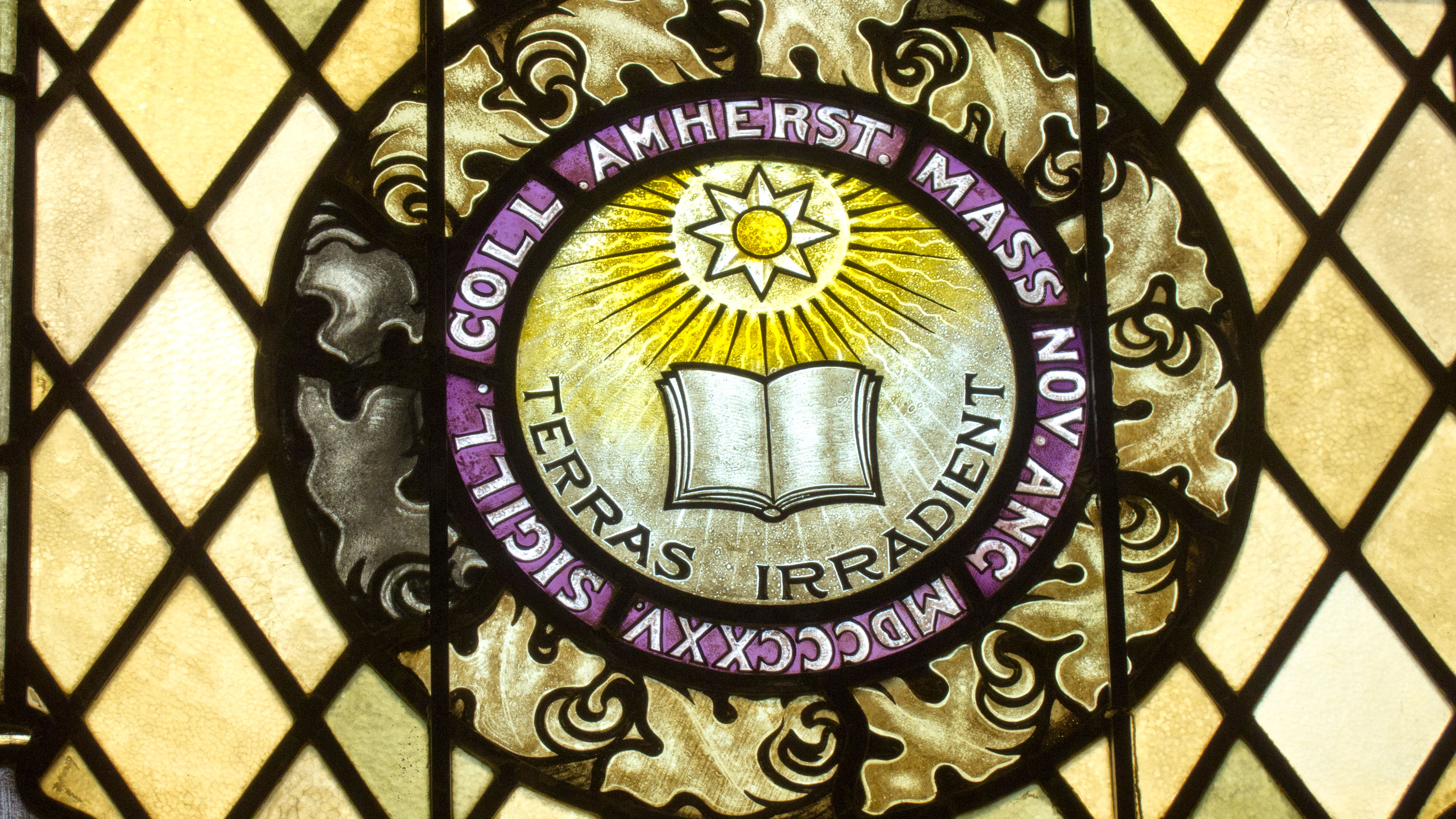 A stained-glass window depicting the Amherst College seal