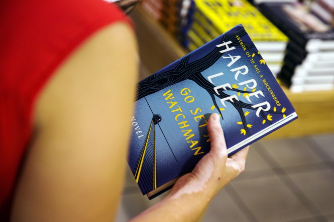 A reader holding "Go Set a Watchman"