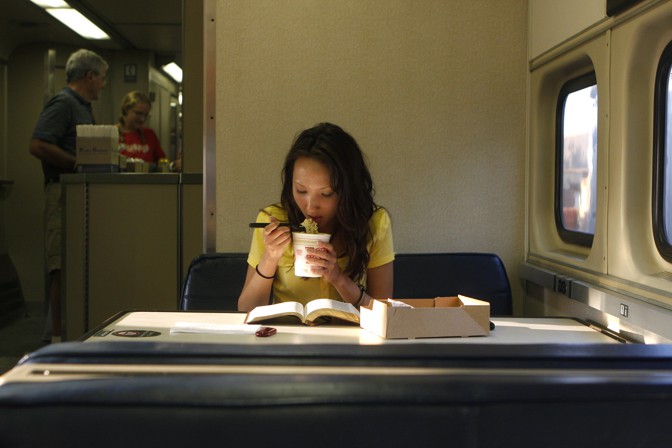 woman eating ramen and reading