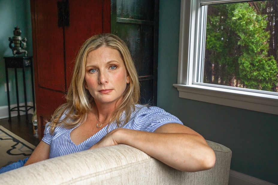 Photo of Jen Middleton sitting with left arm over back of couch by window