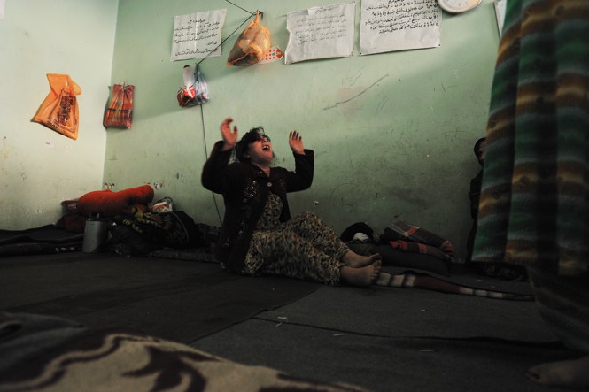 A woman cries in a grief in a female jail cell.