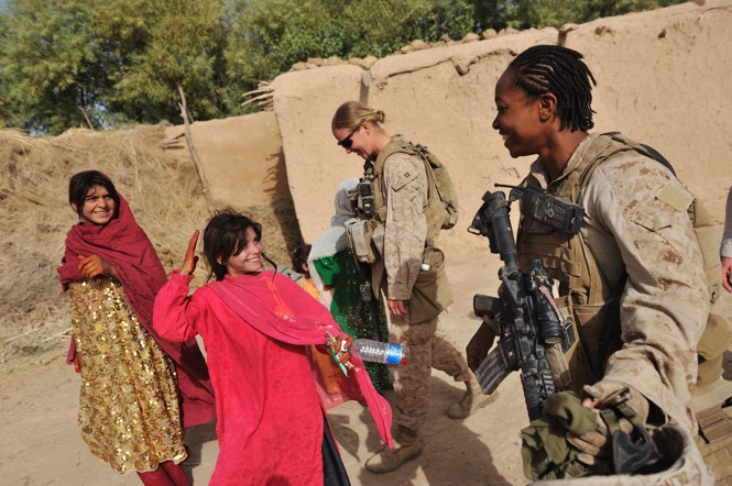 A US soldier laughs with Afghani girls