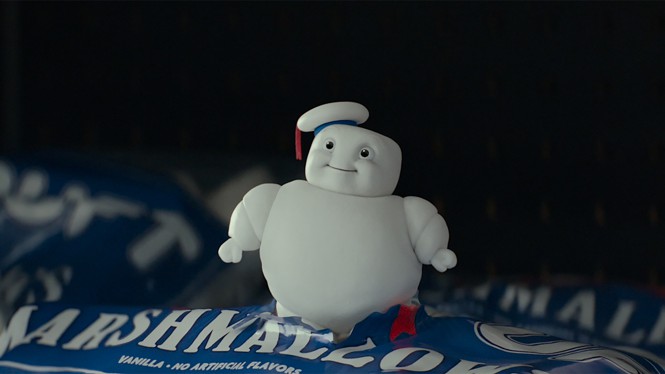 A small animated marshmallow man looks up from a marshmallow bag